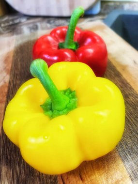 Tahta arka planda taze sarı ve yeşil biberler.