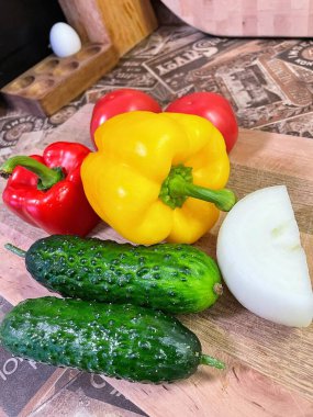 Tahta bir masada taze organik kırmızı biber, sarımsak ve yeşil domates.