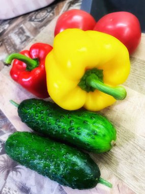 Tahta arka planda taze sarı biber ve salatalık.