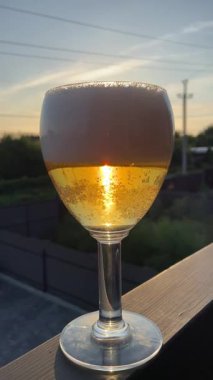 Arka planda güzel bir manzarası olan bir bardak bira. içki ve bira konsepti, yaz zamanı. 