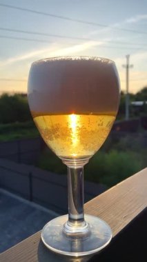 Arka planda güzel bir manzarası olan bir bardak bira. içki ve bira konsepti, yaz zamanı. 