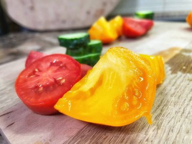 taze organik sebzeler, kırmızı ve sarı domatesler, yeşil salatalık, vegan, ahşap tahtada. 