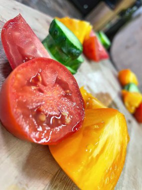 taze organik sebzeler, kırmızı ve sarı domatesler, yeşil salatalık, vegan, ahşap tahtada. 