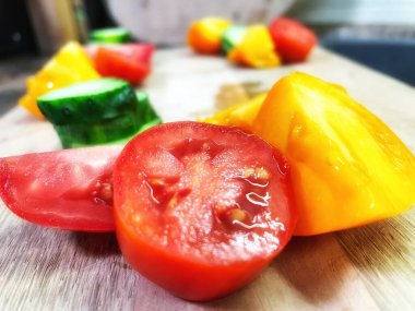 taze organik sebzeler, kırmızı ve sarı domatesler, yeşil salatalık, vegan, ahşap tahtada. 