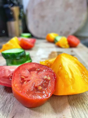 taze organik sebzeler, kırmızı ve sarı domatesler, yeşil salatalık, vegan, ahşap tahtada. 