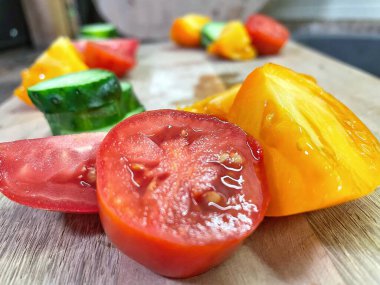 taze organik sebzeler, kırmızı ve sarı domatesler, yeşil salatalık, vegan, ahşap tahtada. 
