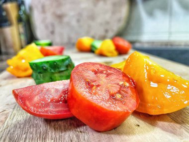 taze organik sebzeler, kırmızı ve sarı domatesler, yeşil salatalık, vegan, ahşap tahtada. 