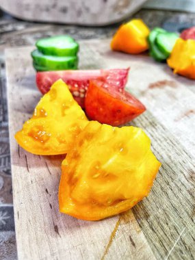 taze organik sebzeler, kırmızı ve sarı domatesler, yeşil salatalık, vegan, ahşap tahtada. 