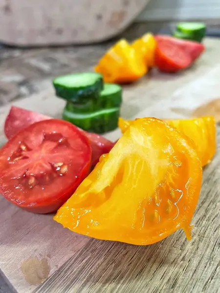 taze organik sebzeler, kırmızı ve sarı domatesler, yeşil salatalık, vegan, ahşap tahtada. 