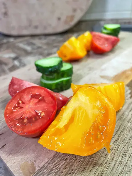 taze organik sebzeler, kırmızı ve sarı domatesler, yeşil salatalık, vegan, ahşap tahtada. 