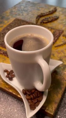 Eşsiz yaratıcı yaklaşım, kahve çekirdekleri ve bir fincan aromatik kahve, zarif ve pahalı.