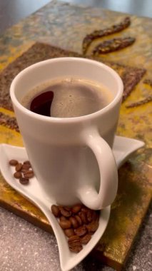 Eşsiz yaratıcı yaklaşım, kahve çekirdekleri ve bir fincan aromatik kahve, zarif ve pahalı.