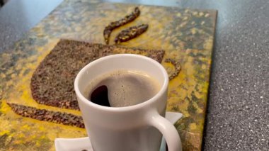 Eşsiz yaratıcı yaklaşım, kahve çekirdekleri ve bir fincan aromatik kahve, zarif ve pahalı.