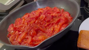 Domatesler yağ dolu bir tavada pişirilir.