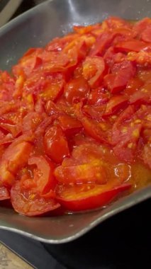 Domatesler yağ dolu bir tavada pişirilir.