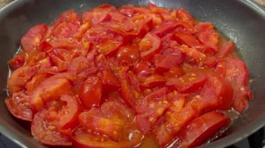 Domatesler yağ dolu bir tavada pişirilir.