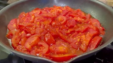 Domatesler yağ dolu bir tavada pişirilir.