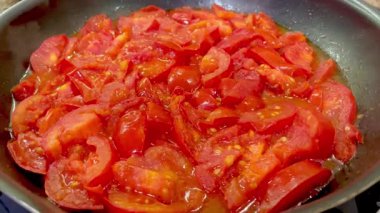 Domatesler yağ dolu bir tavada pişirilir.