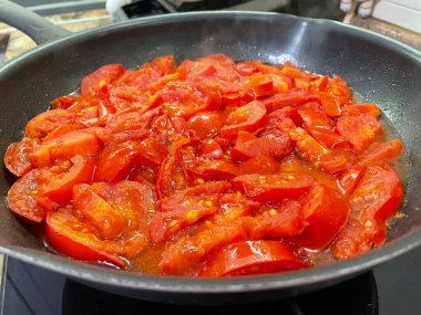 Domatesler yağ dolu bir tavada pişirilir.