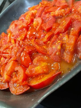 Domatesler yağ dolu bir tavada pişirilir.