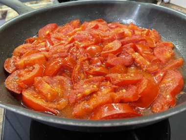 Domatesler yağ dolu bir tavada pişirilir.