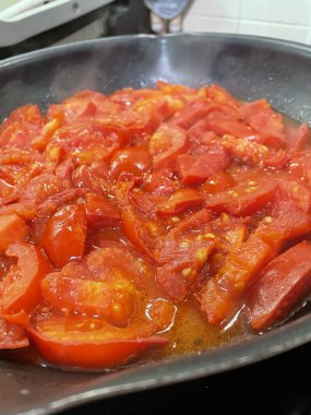 Domatesler yağ dolu bir tavada pişirilir.