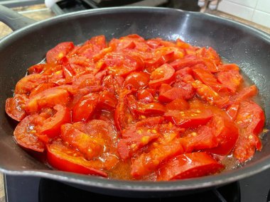 Domatesler yağ dolu bir tavada pişirilir.