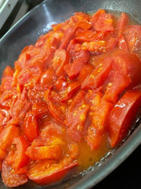 Domatesler yağ dolu bir tavada pişirilir.