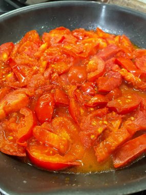 Domatesler yağ dolu bir tavada pişirilir.