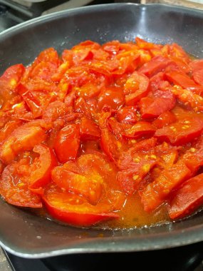 Domatesler yağ dolu bir tavada pişirilir.