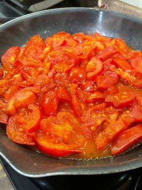 Domatesler yağ dolu bir tavada pişirilir.