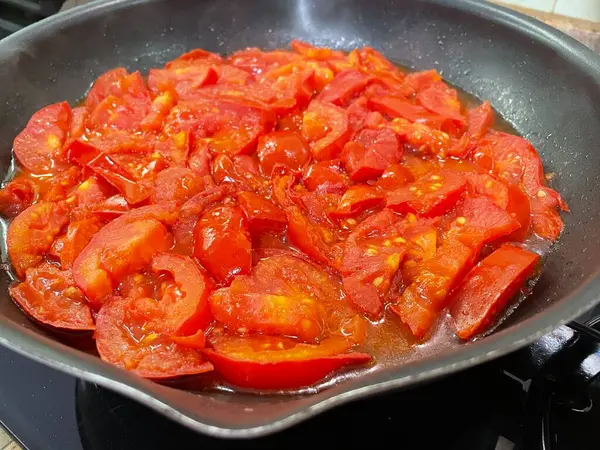 Domatesler yağ dolu bir tavada pişirilir.