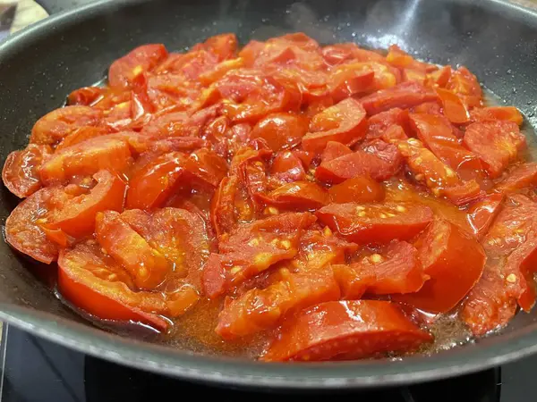 Domatesler yağ dolu bir tavada pişirilir.