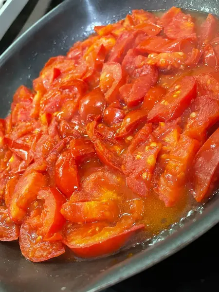 Domatesler yağ dolu bir tavada pişirilir.