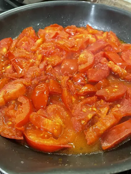 Domatesler yağ dolu bir tavada pişirilir.