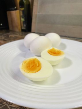 Beyaz bir tabakta haşlanmış yumurta, kahvaltı, öğle yemeği.