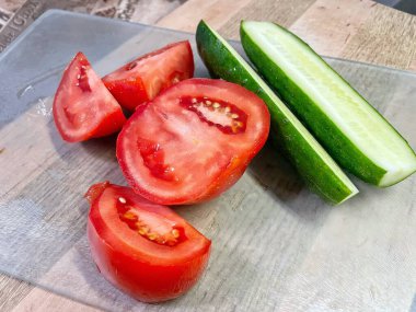 Beyaz arka planda taze kırmızı domates ve salatalık.