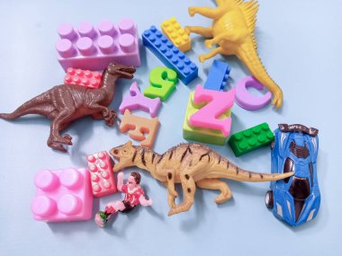 Çocuk oyuncakları geçmişi. Renkli bloklar, alfabe oyuncakları ve dinazorlar gökyüzündeki mavi arka plan çerçevesi.