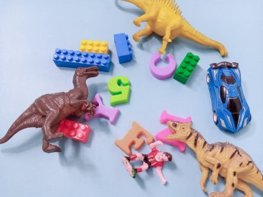 Çocuk oyuncakları geçmişi. Renkli bloklar, alfabe oyuncakları ve dinazorlar gökyüzündeki mavi arka plan çerçevesi.