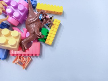 Çocuk oyuncakları geçmişi. Renkli bloklar, alfabe oyuncakları ve dinazorlar gökyüzündeki mavi arka plan çerçevesi.