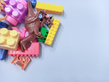 Çocuk oyuncakları geçmişi. Renkli bloklar, alfabe oyuncakları ve dinazorlar gökyüzündeki mavi arka plan çerçevesi.