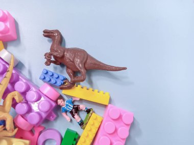 Çocuk oyuncakları geçmişi. Renkli bloklar, alfabe oyuncakları ve dinazorlar gökyüzündeki mavi arka plan çerçevesi.