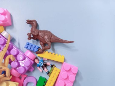 Çocuk oyuncakları geçmişi. Renkli bloklar, alfabe oyuncakları ve dinazorlar gökyüzündeki mavi arka plan çerçevesi.