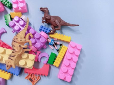 Çocuk oyuncakları geçmişi. Renkli bloklar, alfabe oyuncakları ve dinazorlar gökyüzündeki mavi arka plan çerçevesi.