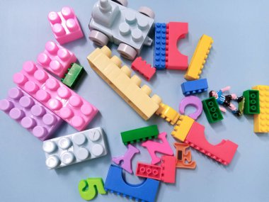 Çocuk oyuncakları geçmişi. Gökyüzü mavi arka planında renkli bloklar ve alfabe oyuncakları.