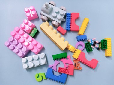 Çocuk oyuncakları geçmişi. Gökyüzü mavi arka planında renkli bloklar ve alfabe oyuncakları.