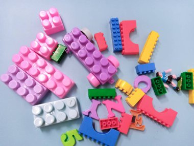 Çocuk oyuncakları geçmişi. Gökyüzü mavi arka planında renkli bloklar ve alfabe oyuncakları.