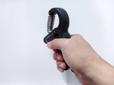 Beyaz arka planda el egzersizi yapan genç adamlar izole edilmiş. Sağ el, kas antrenmanını sıkıca tutar.