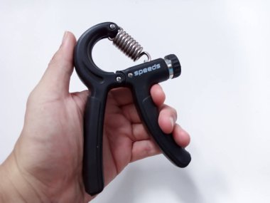 Beyaz arka planda el egzersizi yapan genç adamlar izole edilmiş. Sağ el, kas antrenmanını sıkıca tutar.