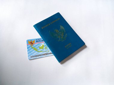 Endonezya Cumhuriyeti yeşil pasaport ve Endonezya kimlik kartı beyaz arka planda insan elinde..